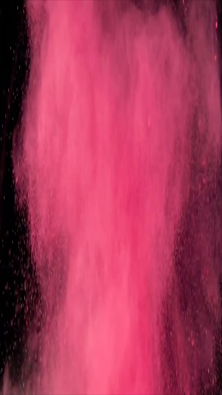 Esplosione di polvere rosa su sfondo nero al rallentatore