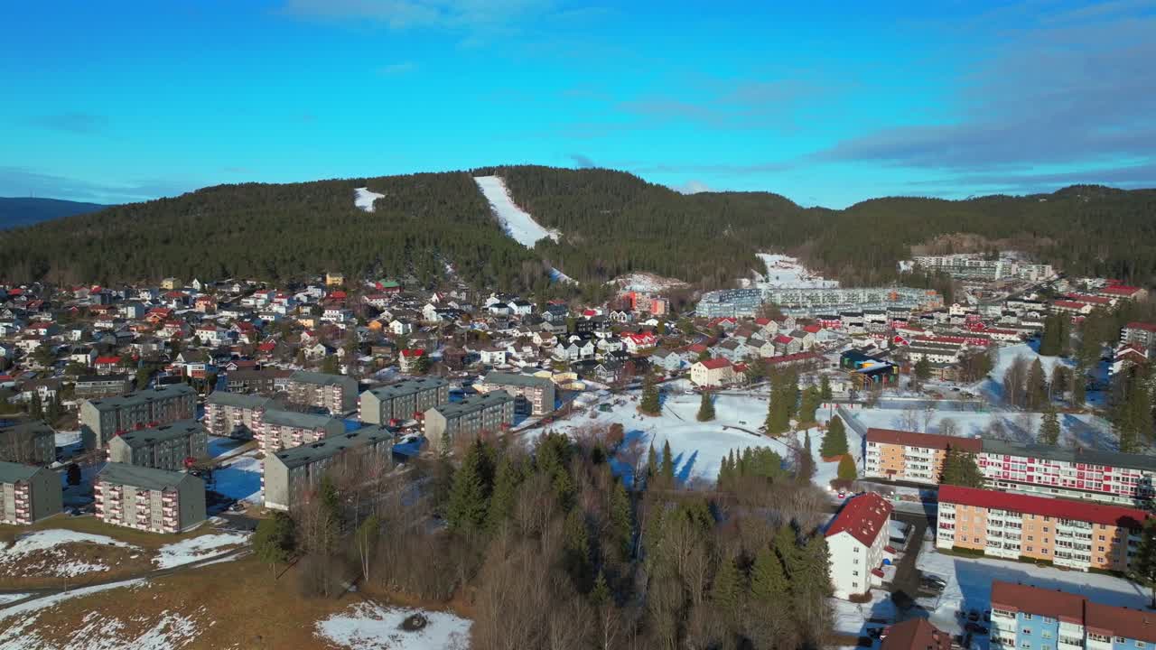 Sunny blue sky daytime Oslo Skisenter Skimore Norway Norge aerial drone mountain hill Norwegian winter Bjerke Travbane Tonsenhagen apartment buildings Nordmarka forest icy snowy trails circle right