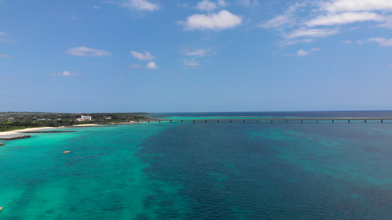 화창한 날 청록색 물의 공중 전망, 일본 미야코지마 배경의 다리를 지나가는 자동차