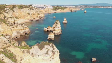 crumbling pieces of land off the coast of lagos, algarve, portugal - aerial fly-over tracking shot