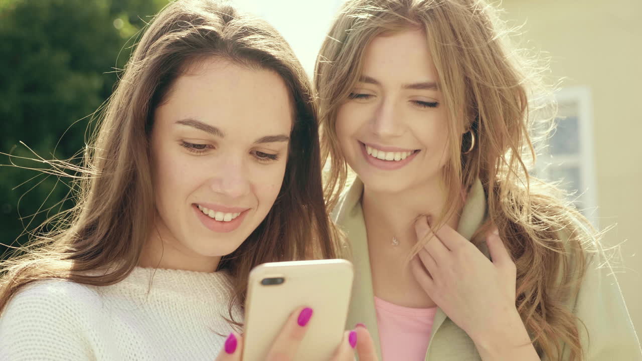 dos amigos mirando un teléfono inteligente