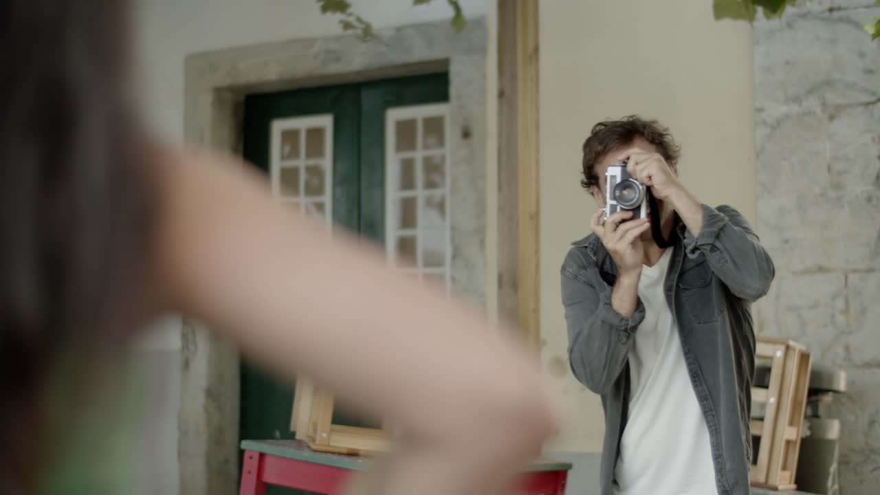 젊은 백인 남자가 히스패닉 여자친구의 사진을 찍고 있습니다.