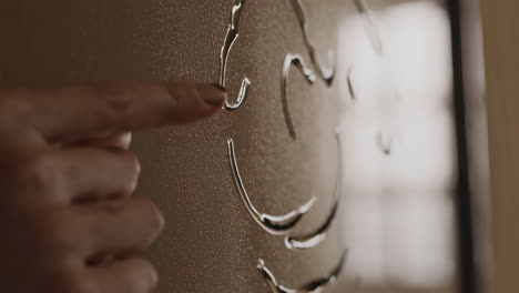 hand pointing to a drawing on glass