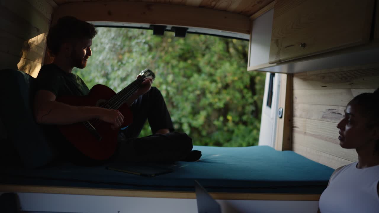 Couple enjoying van life with music and nature views
