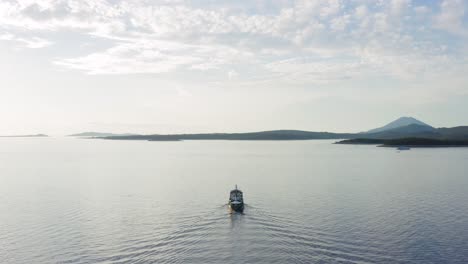 boat sailing across the northern adriatic sea in the town of mali losinj, island of losinj in croatia - drone pullback shot