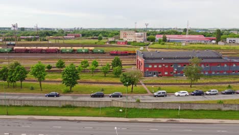 Vista-Aérea-Del-Patio-De-Trenes-Y-Edificios-Industriales-Con-Autos-Estacionados