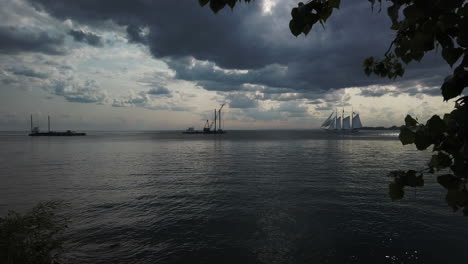 Late-afternoon-wide-shot-with-two-barges-and-a-tall-ship-meeting-on-the-Great-Lakes