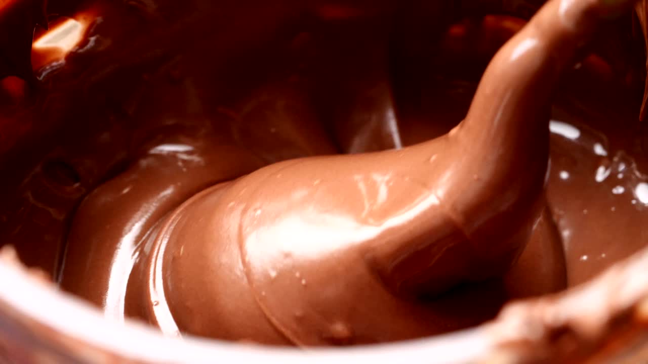 Stirring melted chocolate with a spoon.