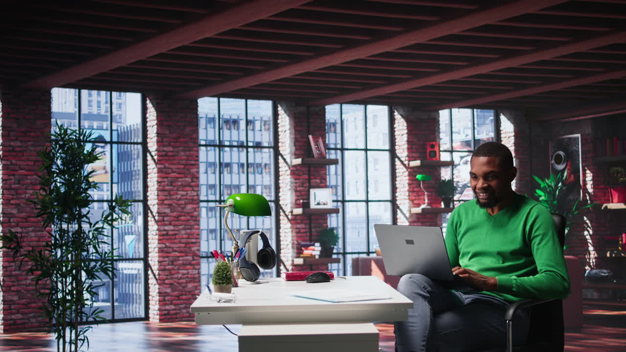 Vertical Video African american guy in loft opening laptop in the morning to work