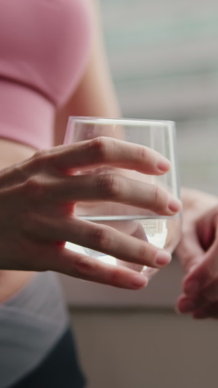 Woman Drinking Water on Balcony After Fitness
