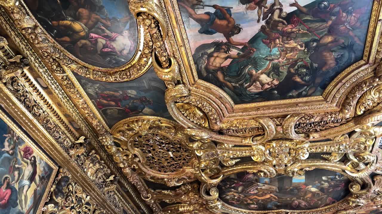 Ornate ceiling with rich paintings and gold details in Doge's Palace in Venice, Italy