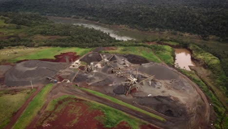 aerial shot of rock piles and excavators working in open stone quarry in brazil