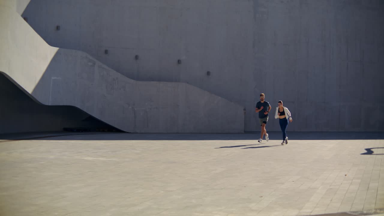 Casal correndo em ambiente urbano
