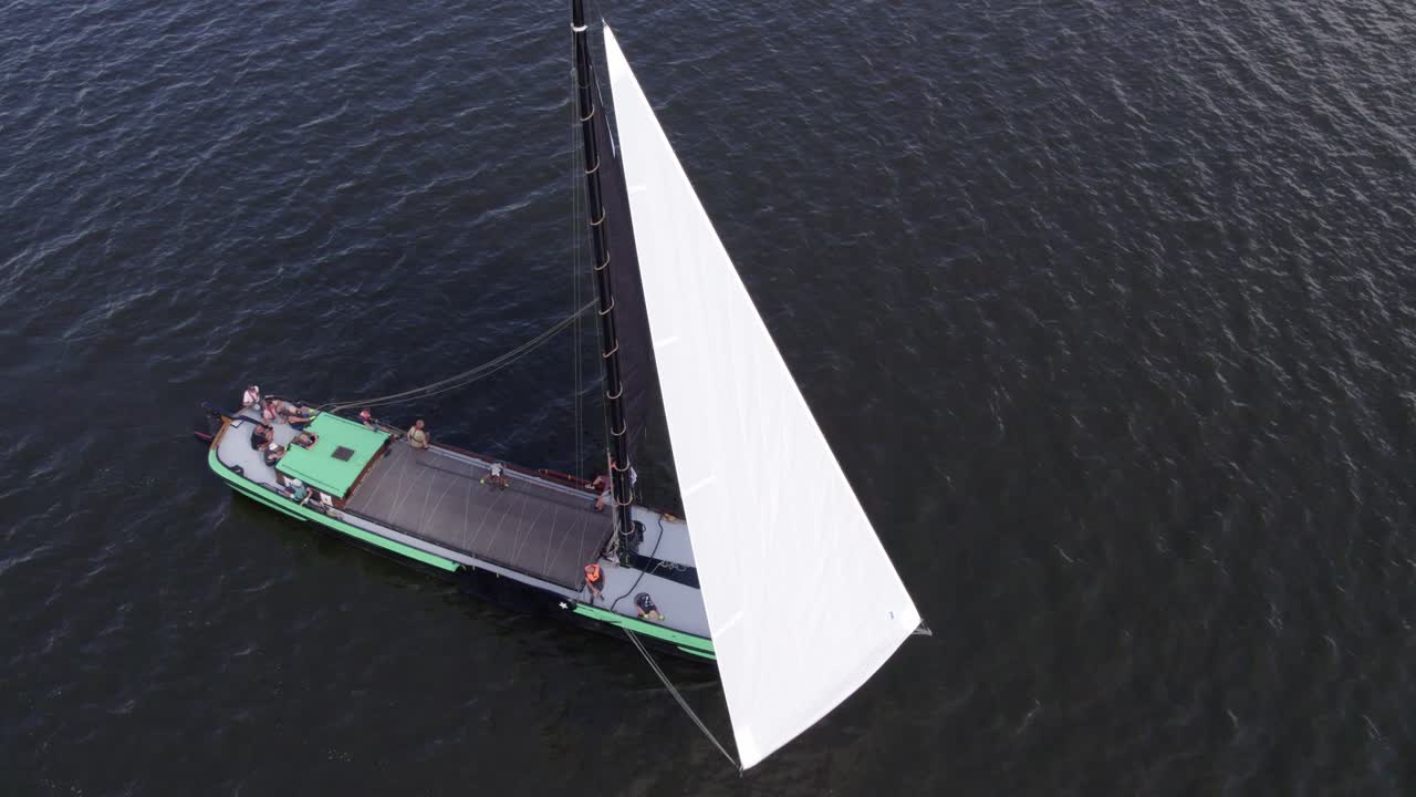 Vista aerea delle tradizionali barche skutsjesilen sul lago Tjeukemeer a Echtenerbrug, Paesi Bassi, con splendida illuminazione all'alba, atmosfera serena, riprese drone di alta qualità che catturano momenti sereni