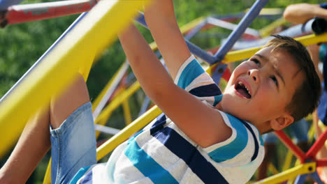 Sorgloser-Schuljunge,-Der-Auf-Dem-Kuppelkletterer-Auf-Dem-Spielplatz-Spielt