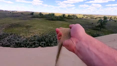 cámara lenta - una mano llena de arena que se lleva el viento