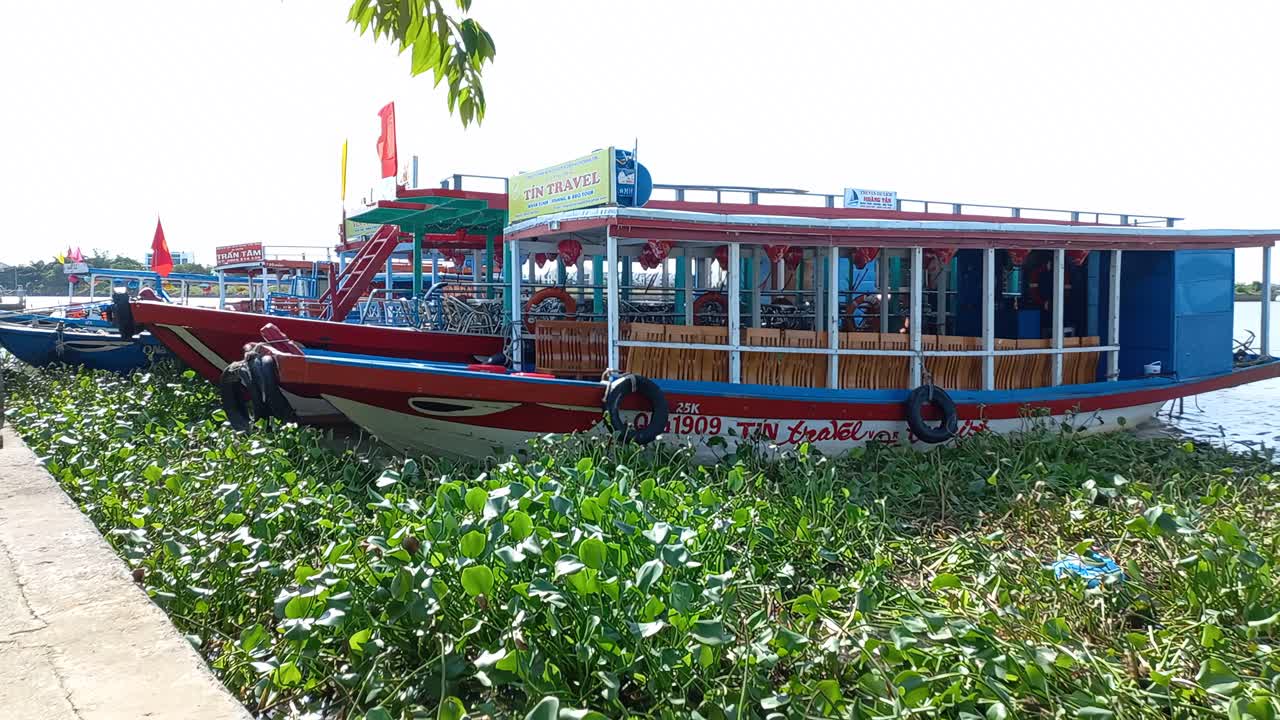 Berthed motor launches waiting to take tourists on trips to locations outside of Hoi An, Vietnam