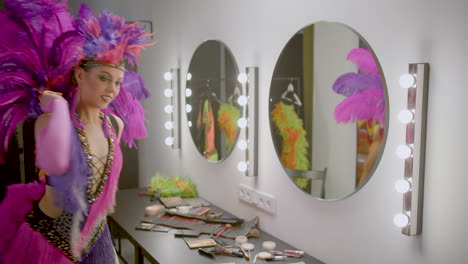 chica de cabaret aplicando maquillaje en el backstage