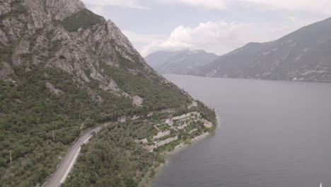 droneshot over the city limone italy on lake garda on a grey day with mountains clouds and water log