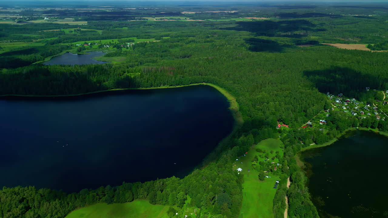 Naturalne jeziora, zielone pola, las – krajobraz z lotu drona
