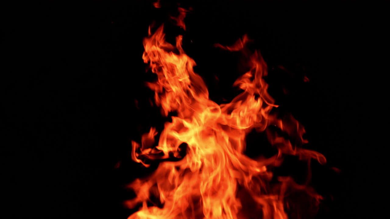 Beautiful orange fire burning at night. Hot fire flames going up on the wind.