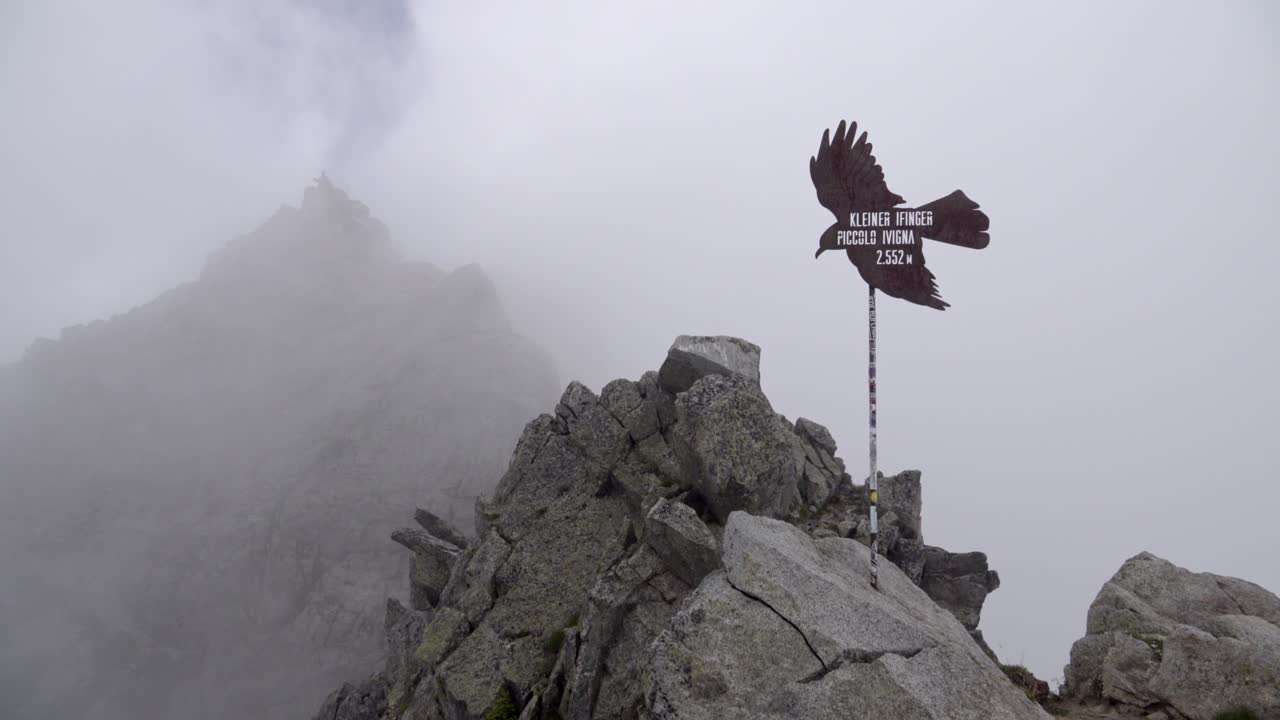 Mount Little Ifinger with fog drifting across Mount Ifinger in the background on an overcast day.
