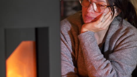 Young-woman-relaxes-in-front-of-fireplace.-Slow-motion