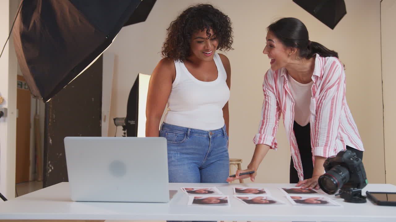fotógrafo con una clienta editando imágenes de una sesión de fotos de retrato en una tableta digital