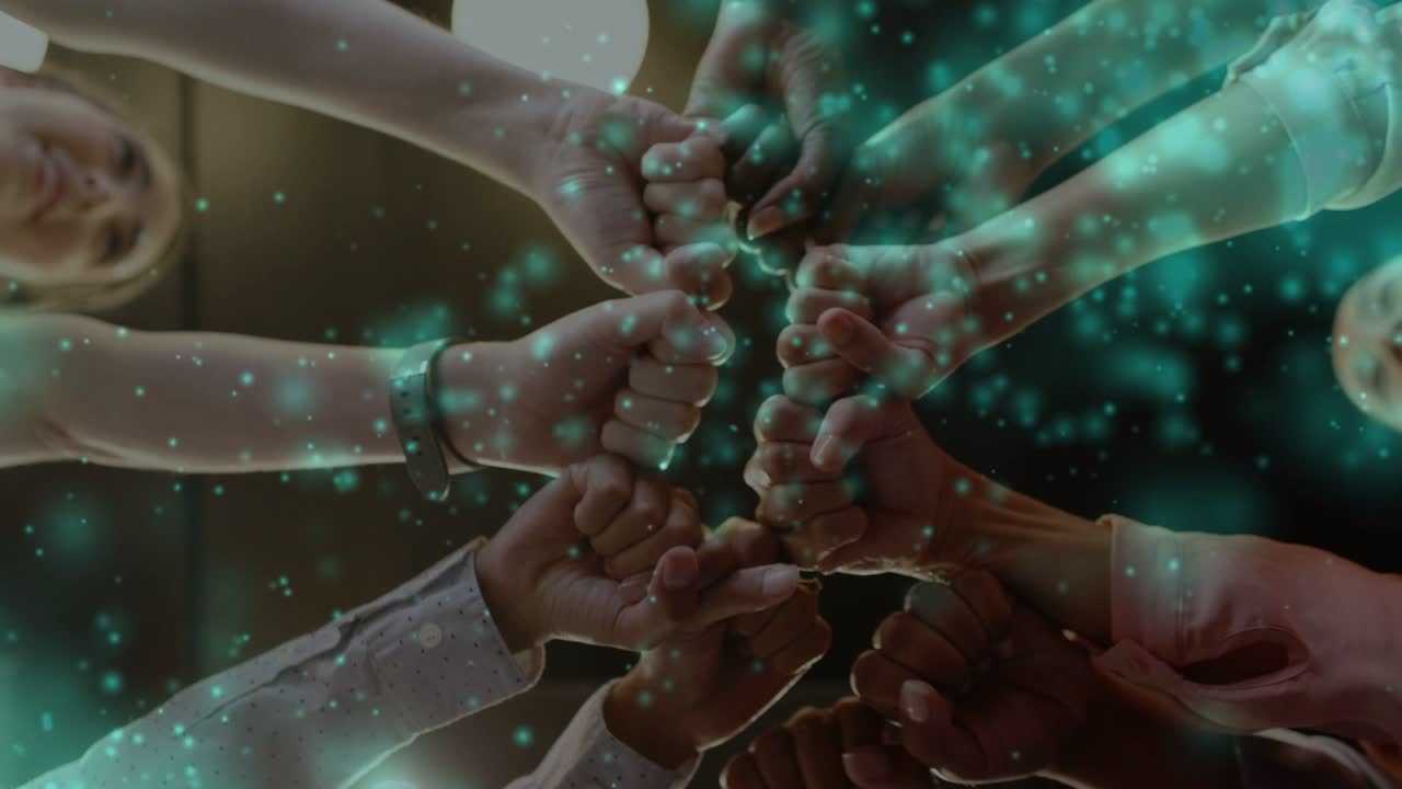 Women reaching in meeting, initiating team fist huddle, teal particles swirling, hands pulling back