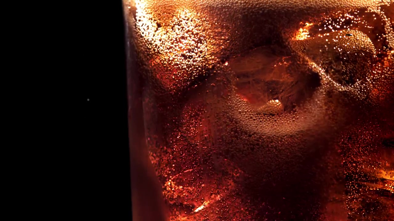 Primo piano di cola rinfrescante con ghiaccio e bollicine