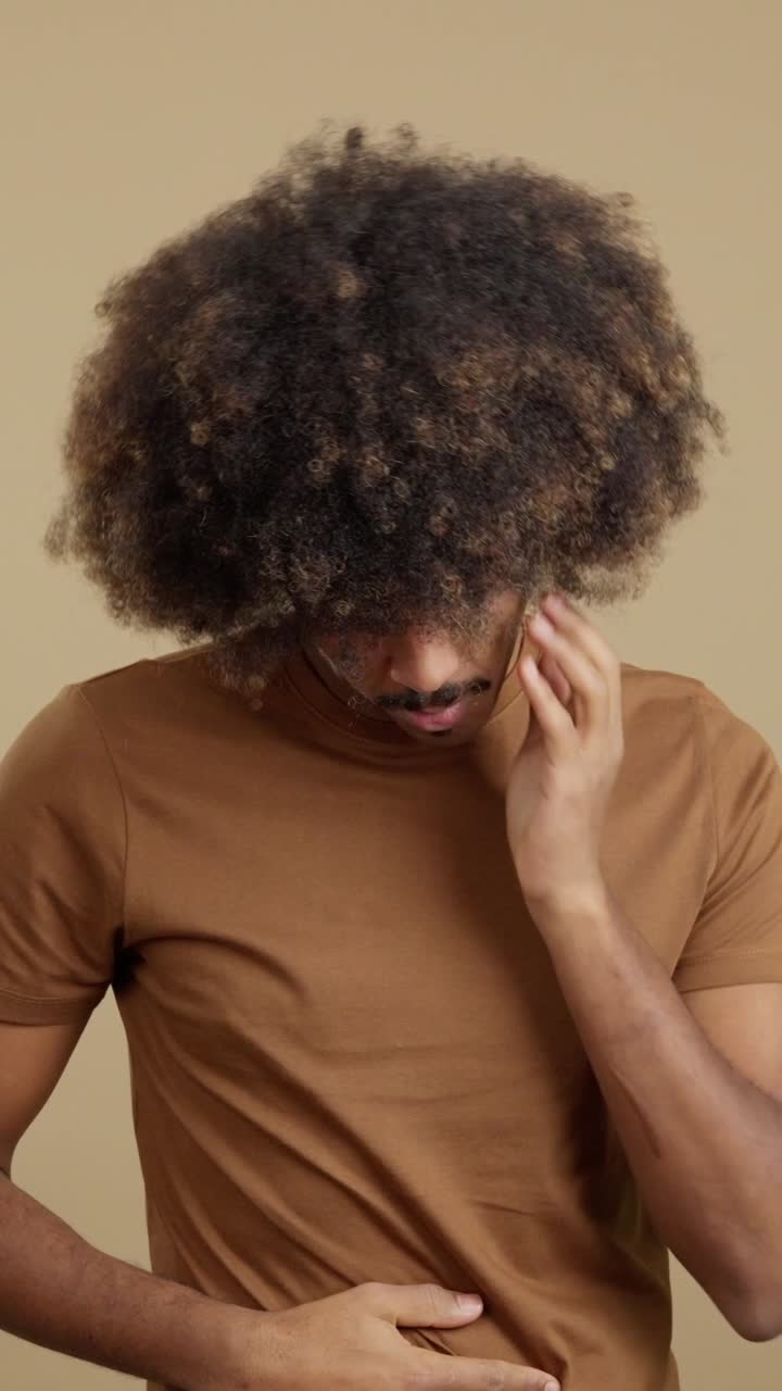 Man experiencing discomfort and pain, possibly headache and stomach ache