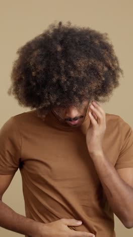man experiencing discomfort and pain, possibly headache and stomach ache