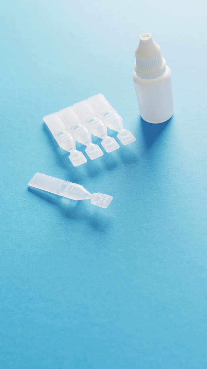 파란색 배경에 의료 방울과 실험 튜브의 수직 비디오