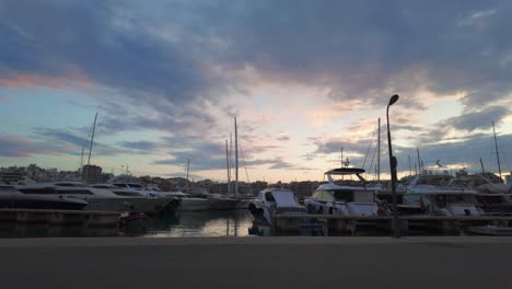 Sunset over a tranquil marina filled with yachts and boats