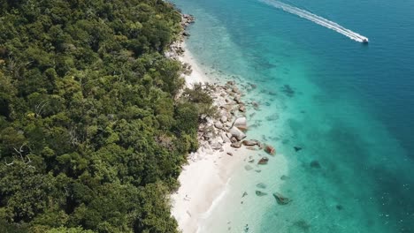 Drohnenantenne-über-Tropischem,-Blauem,-Klarem-Wasser-Und-Weißem-Sandstrand-Mit-Einer-Bewaldeten-Insel-Mit-Einem-Schnellboot