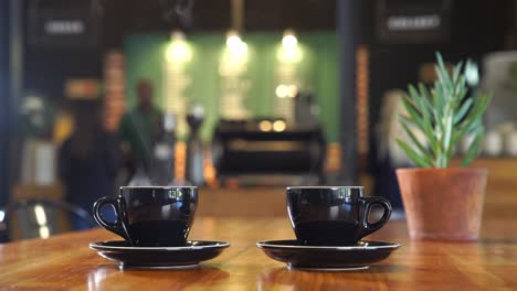 a shot of two steaming cups of hot coffee being served