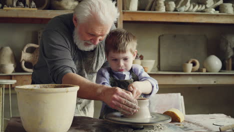 grandfather and grandson working with clay pottery