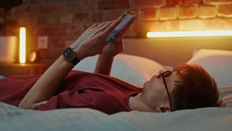 man using smartphone in bed at night