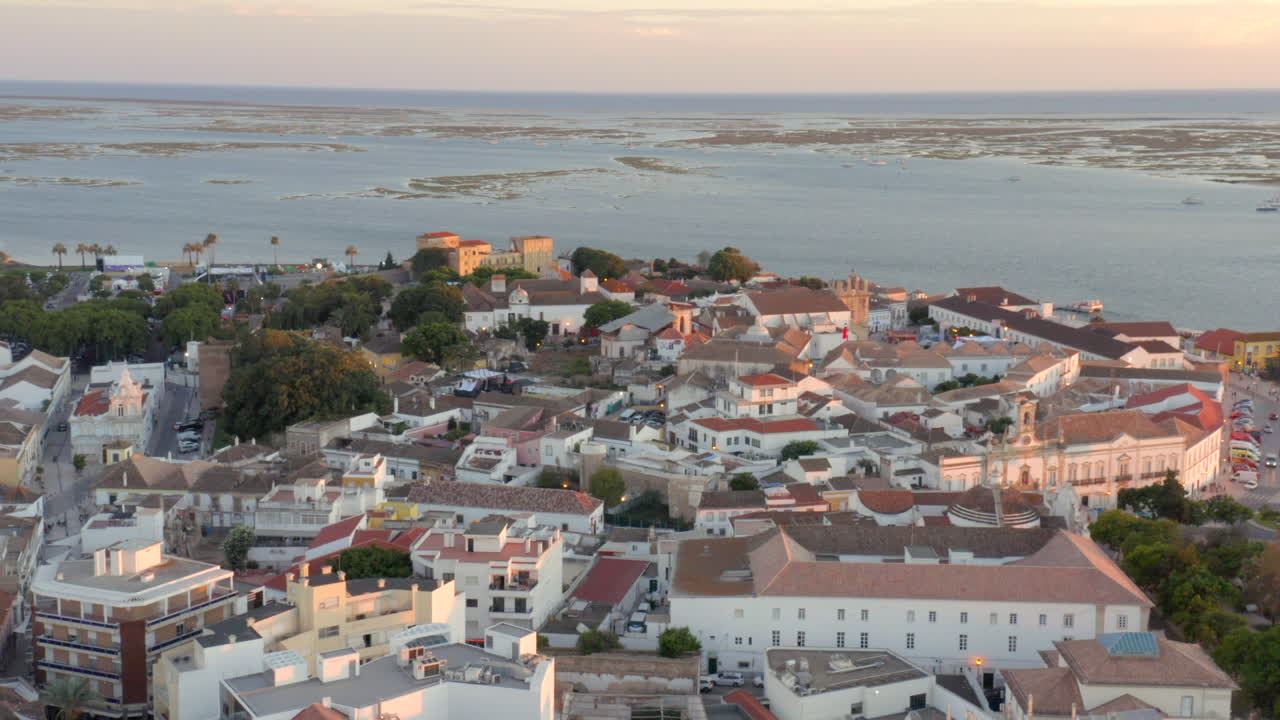 Drone su Faro, Portogallo, ripresa all'indietro della città vecchia all'ora d'oro, vista aerea
