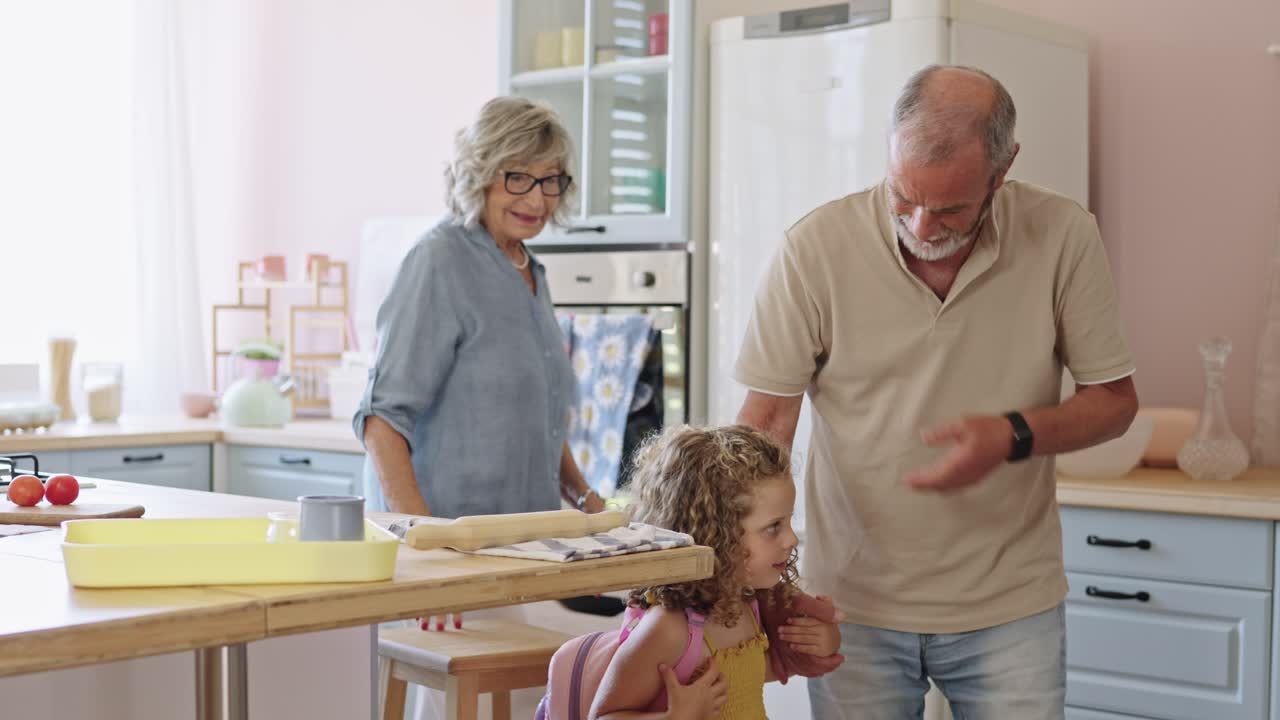 Nonni che cucinano con la nipote in cucina