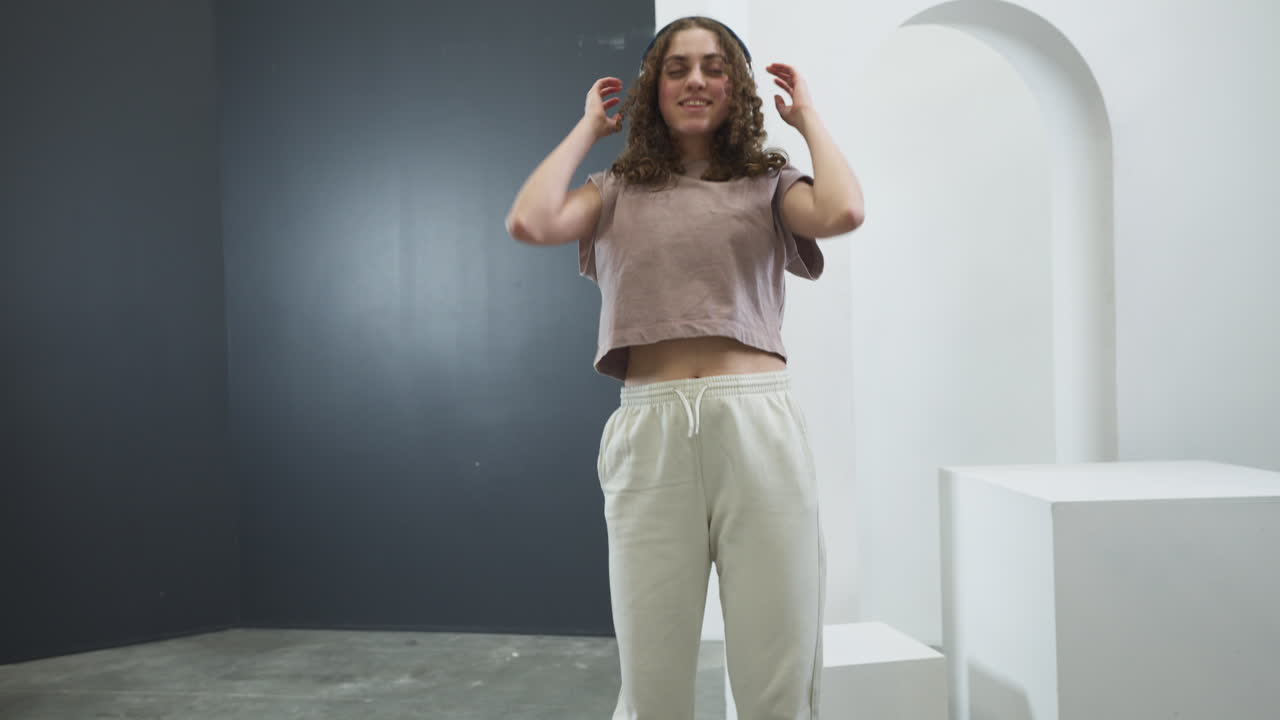 Ragazza adolescente che balla mentre ascolta musica con le cuffie. Rallentatore.