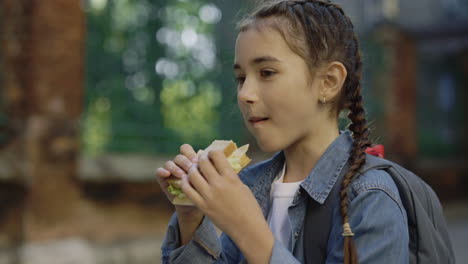 girl eating a sandwich outdoors