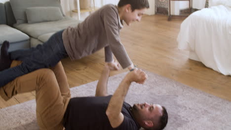 caucasian father having fun with his son at home.