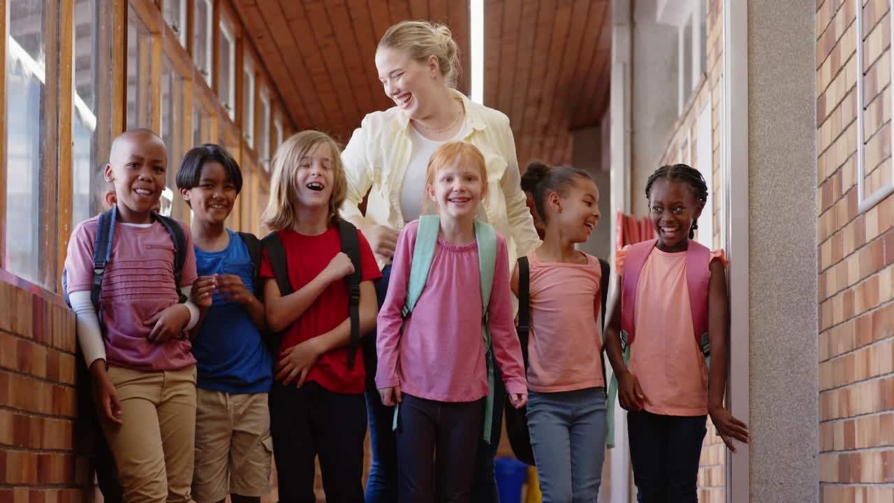 Group of school children walking in hallway with backpacks, smiling and talking