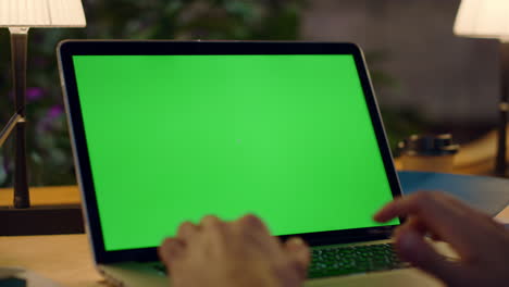 Man-hands-working-on-green-screen-computer