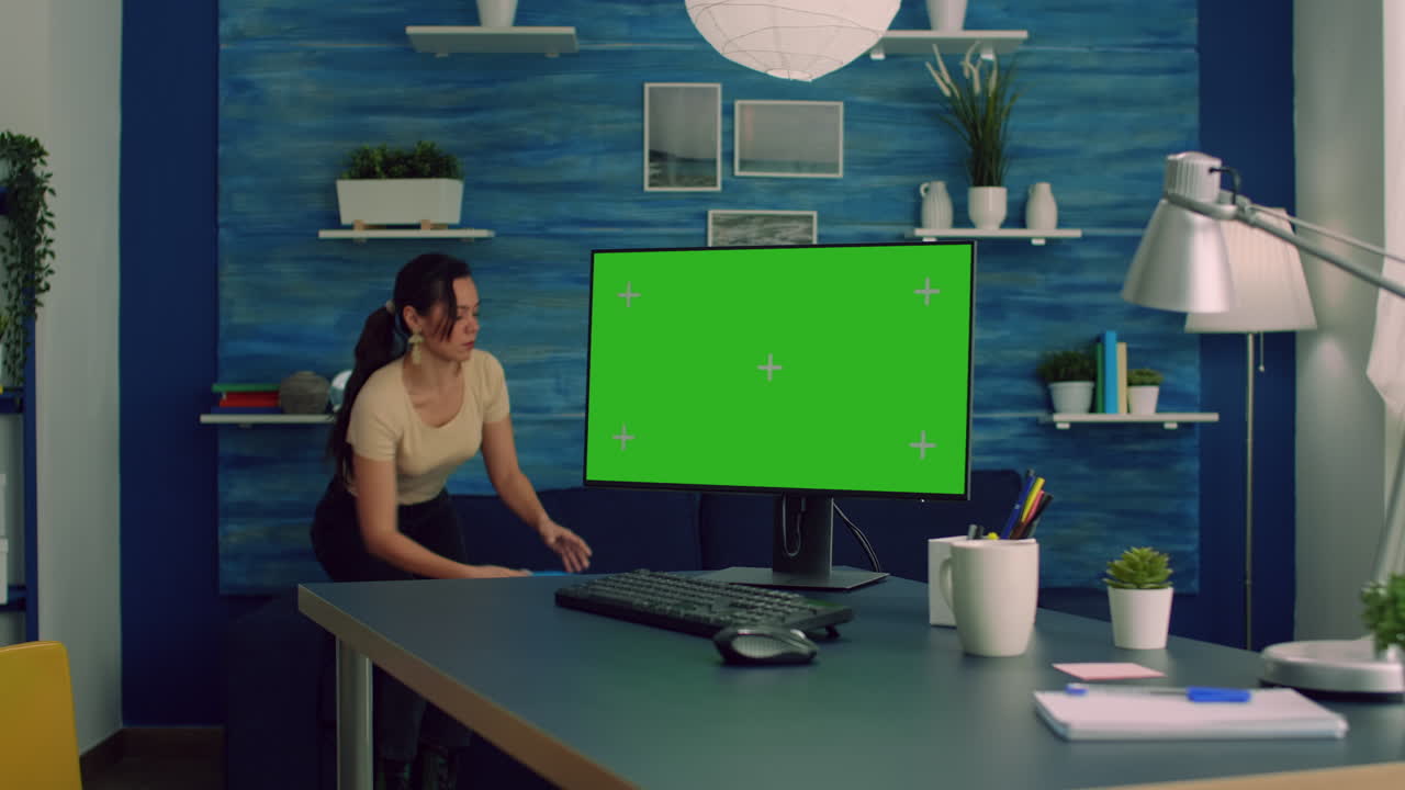 Freelancer working on powerful computer with mock up green screen chroma key display