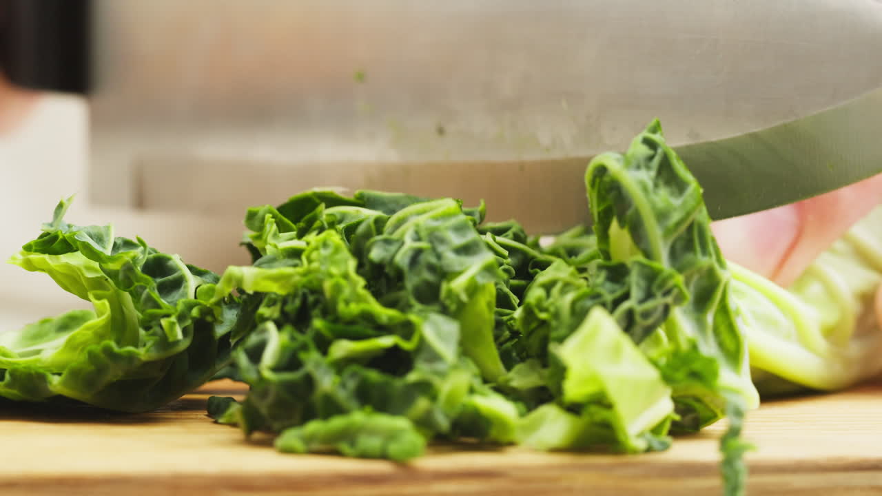 Chopping Fresh Green Cabbage on a Wooden Cutting Board