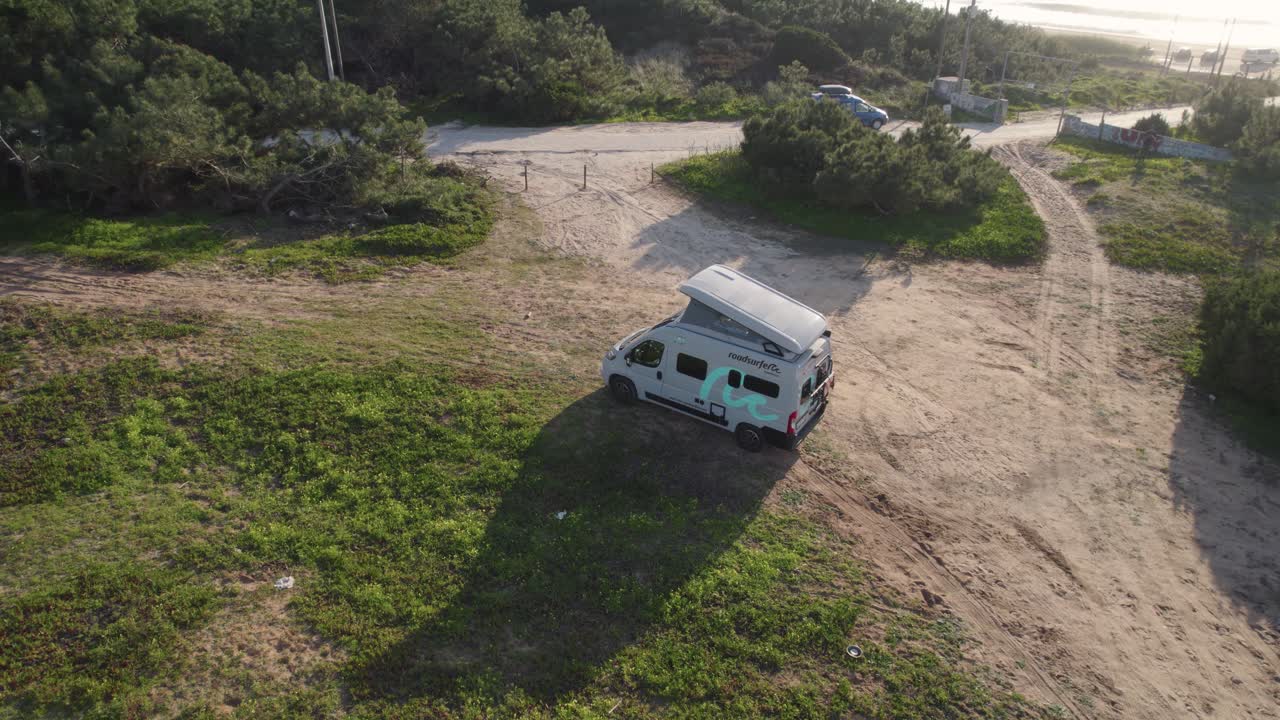 Aerial view approaching campervan motorhome parked on scenic Nazare coast, Portugal