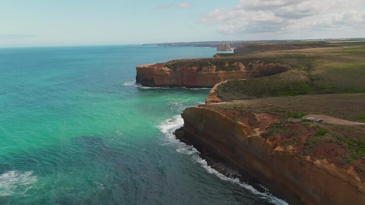 4K Aéreo: costa australiana sobre océano turquesa, plano de alejamiento con dron