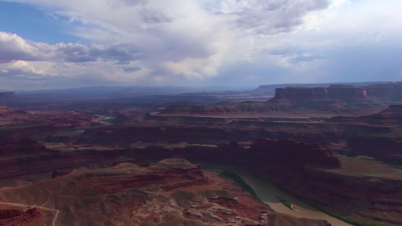 En dal med mesaer på dagtid i Canyonlands nasjonalpark i Utah.